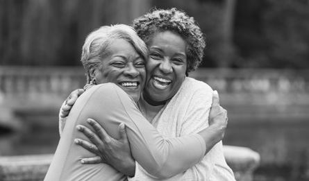 Two older women embrace.