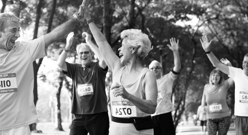 A man and a woman high five each other at the finish of a running race.