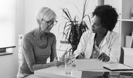  A woman speaks to her doctor while sitting at a table.