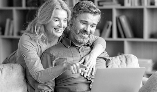A man and woman look at Blue Cross Blue Shield of Michigan Medicare Advantage plans on their laptop