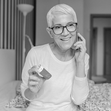 A senior woman talks about her prescription over the phone.