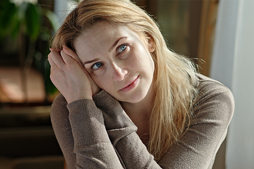 A woman looks upward and off into the distance.