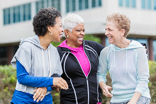 Three women share a laugh while walking.