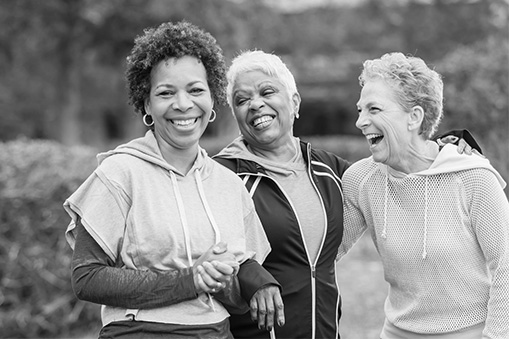 Three women walk and laugh.