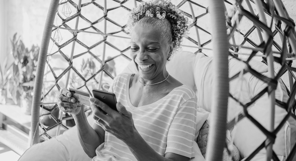 Smiling woman holding a mobile phone and a bank card