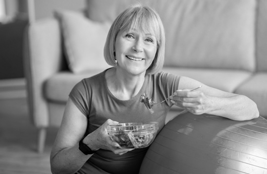 Smiling woman eating a salad