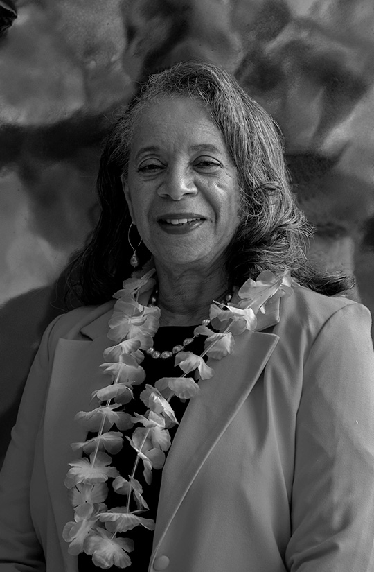 A woman in a pink blazer smiles. 