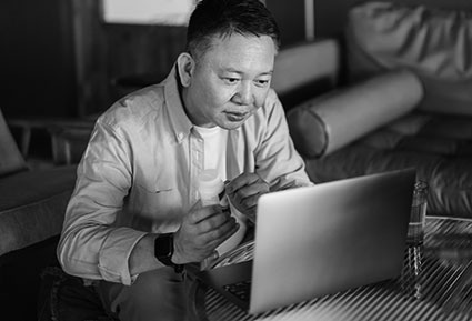 Man standing outside holding a briefcase and looking at a tablet