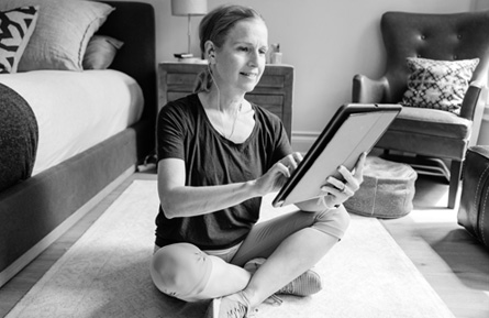 Woman sitting on a floor looking at a tablet