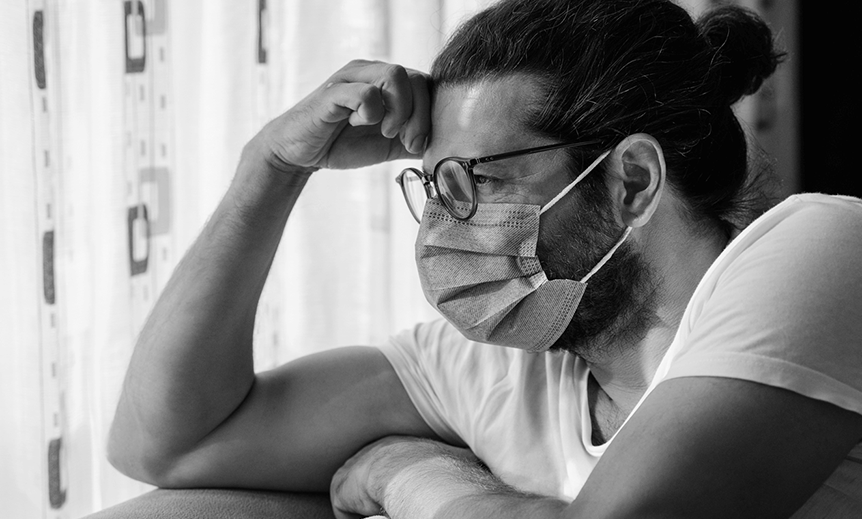 A man struggles with mental health while looking out the window 