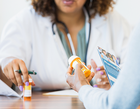 Two women look at prescription bottle labels.