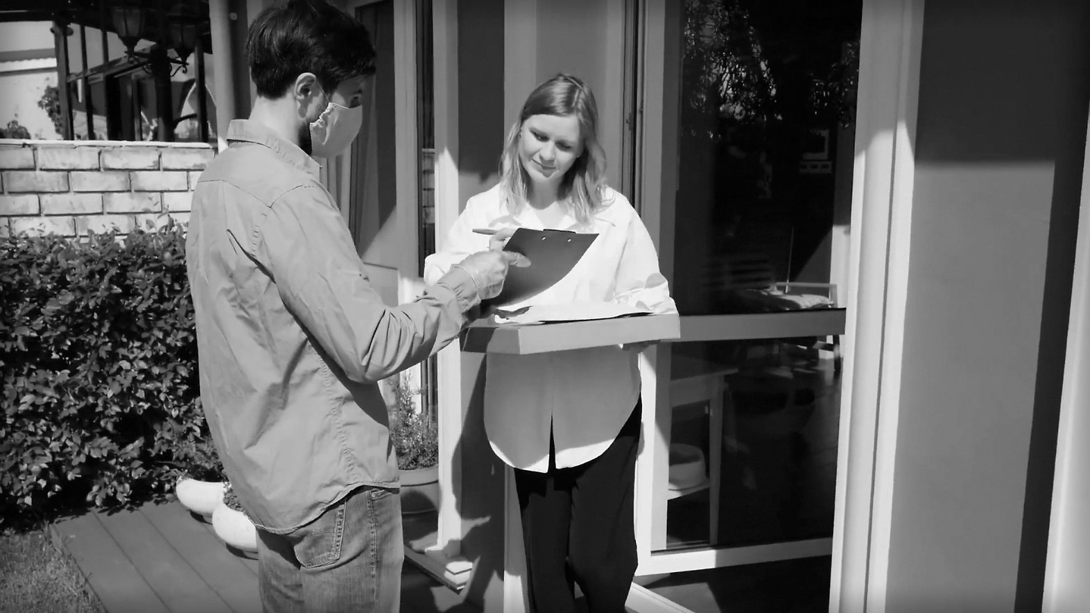 A woman receives a delivery at home. 