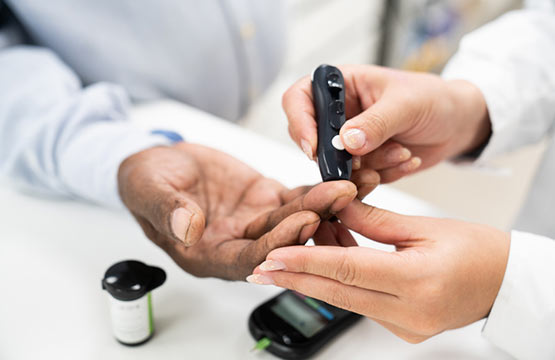 A close-up image of someone checking another person's blood sugar level.