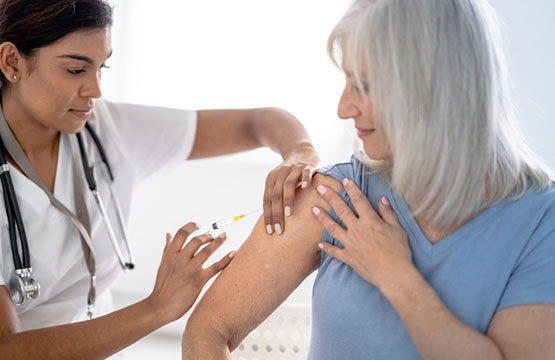 A woman gives another woman a flu shot