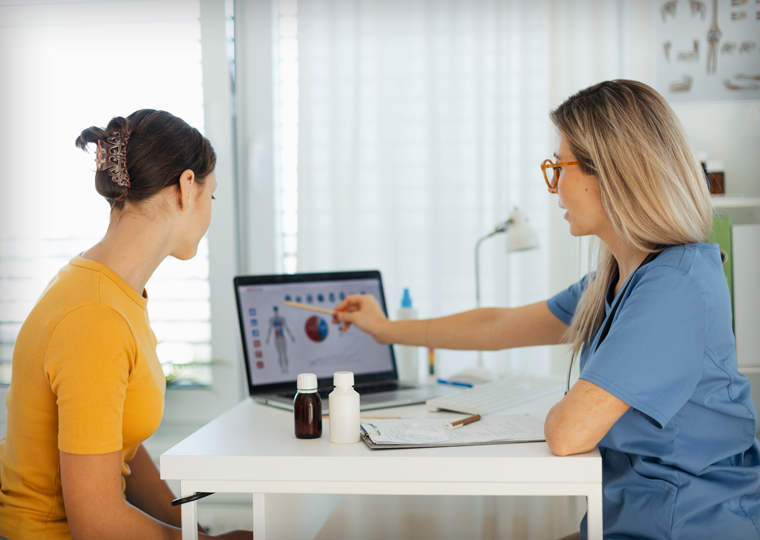 A health care professional reviews a woman's chart with her.