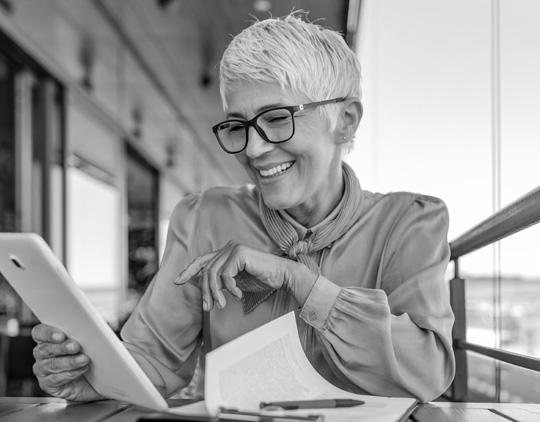 A woman talks with someone on a tablet.