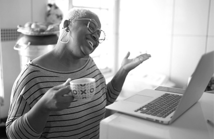 Woman drinks coffee at computer