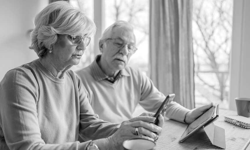 An senior couple look at a mobile device together