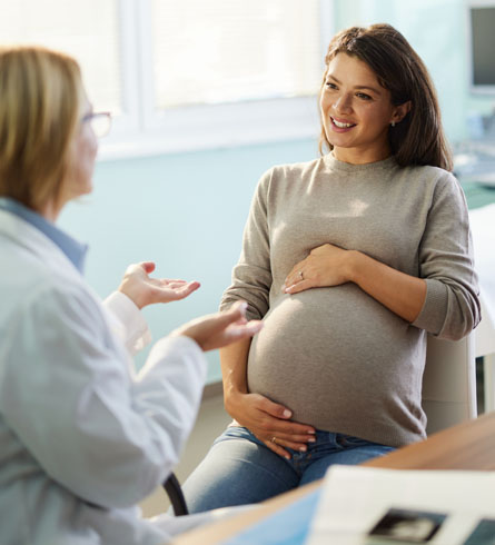 A health care provider speaking with a pregnant woman