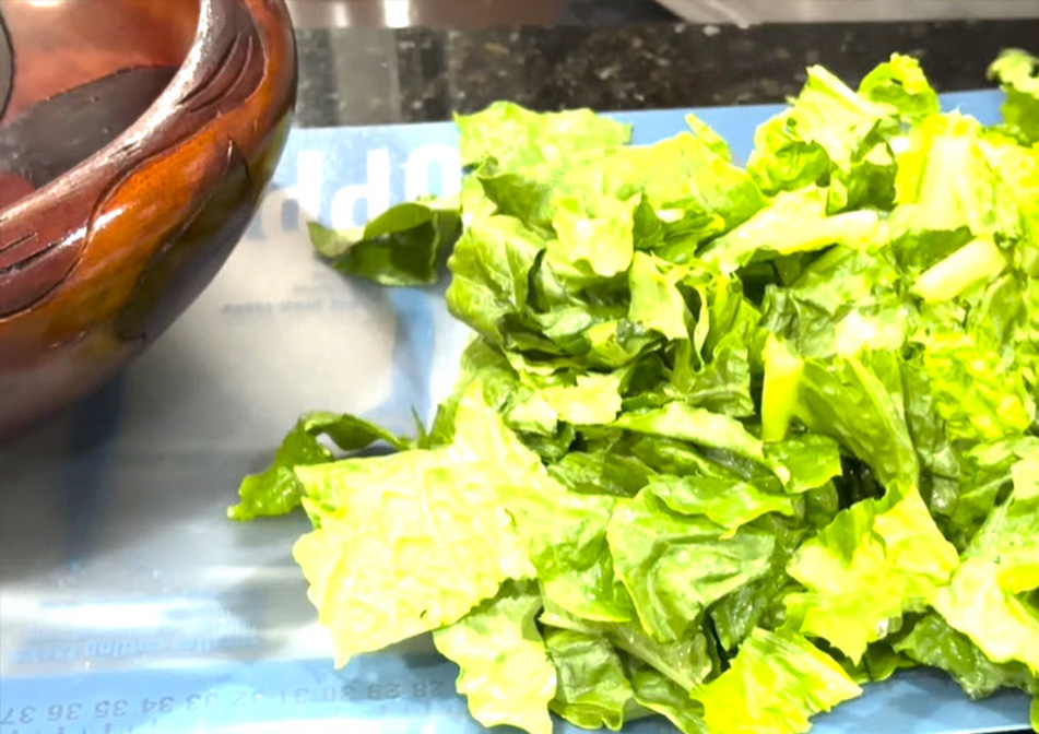 A bunch of chopped lettuce sits on a countertop.