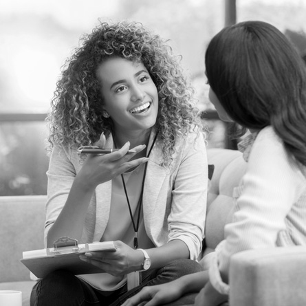 A smiling health insurance agent speaks with a client