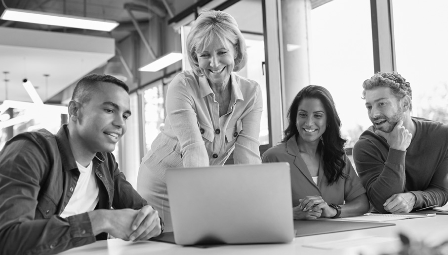 Coworkers look at a laptop together