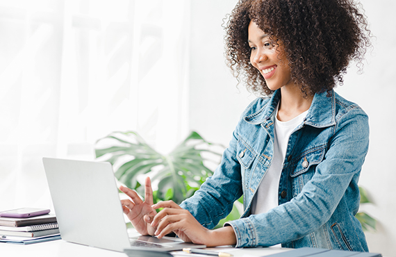 A young woman typing on a laptop