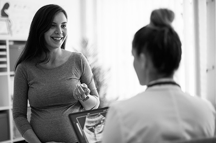 An expecting mother talks with her doctor. 