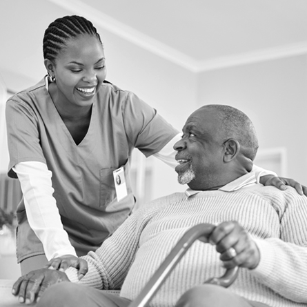 A health care provider assisting a seated elderly patient
