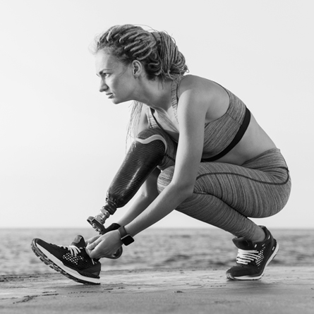 A woman with a prosthetic leg gets ready to run