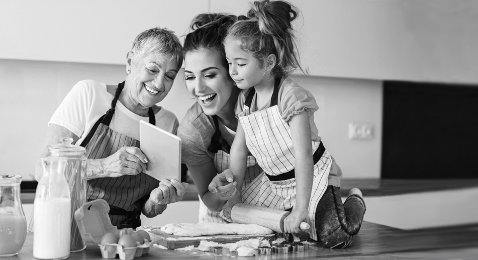 A little girl bakes with her mother and grandmother 