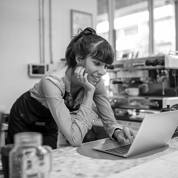 A cafe employee looking at a laptop 