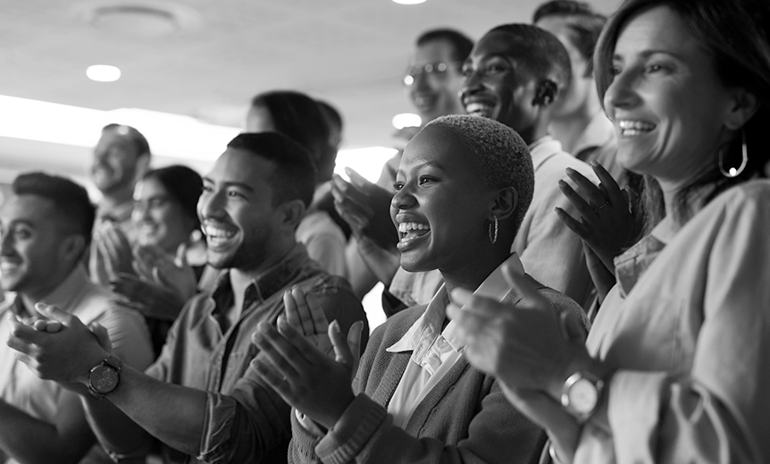 A group stands smiling and clapping