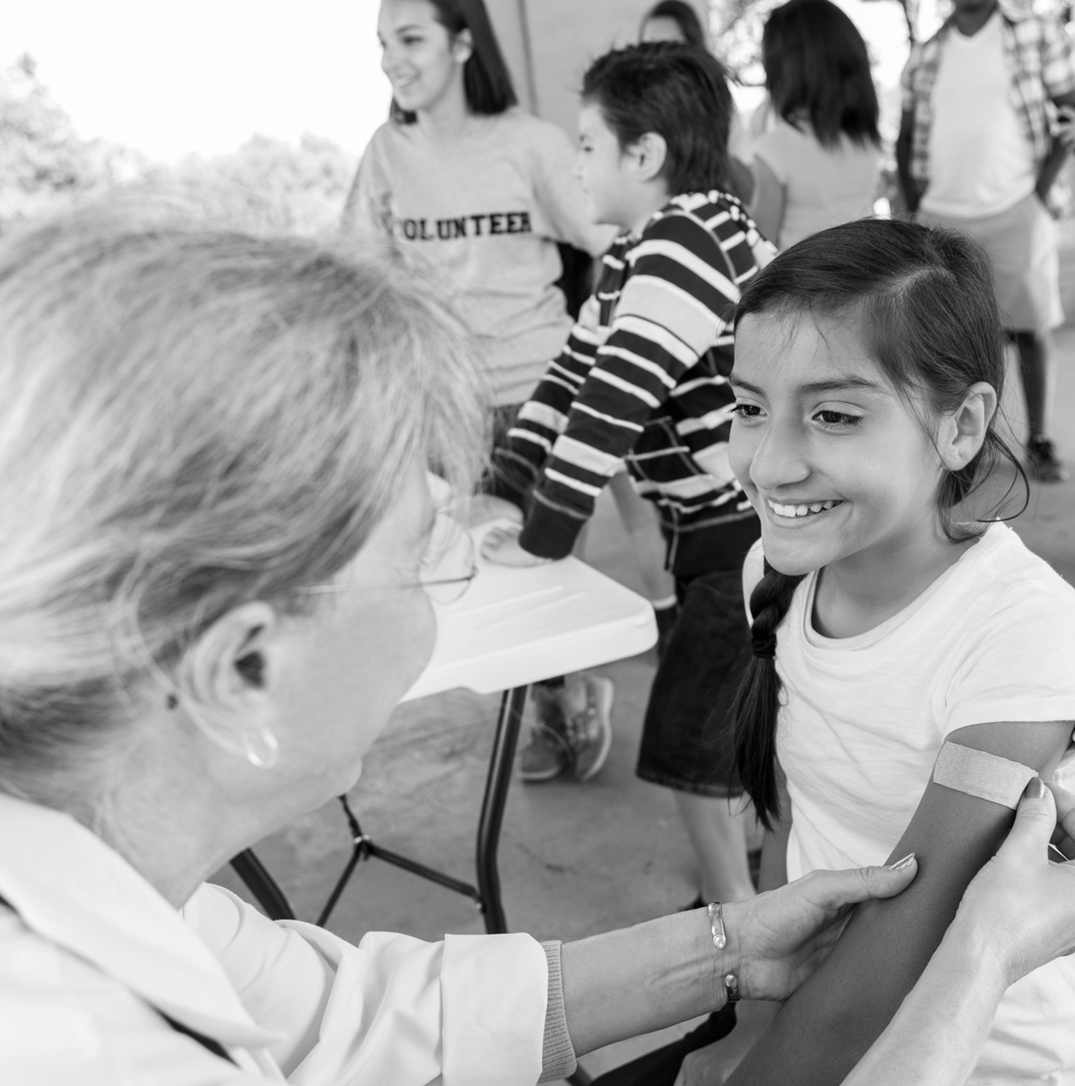 A nurse bandages a young girl's arm