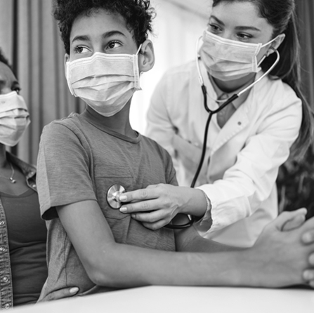 A doctor using her stethoscope on a young patient