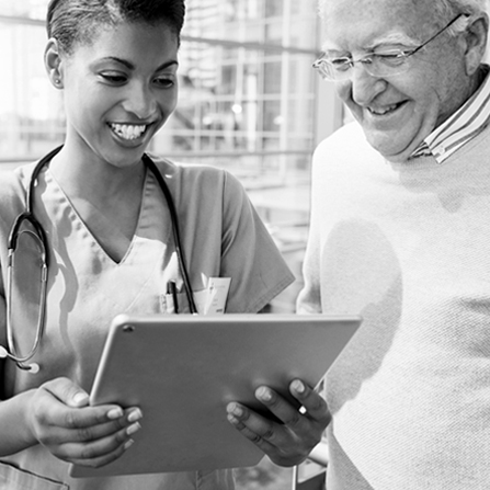 A health care professional and patient look at a tablet together