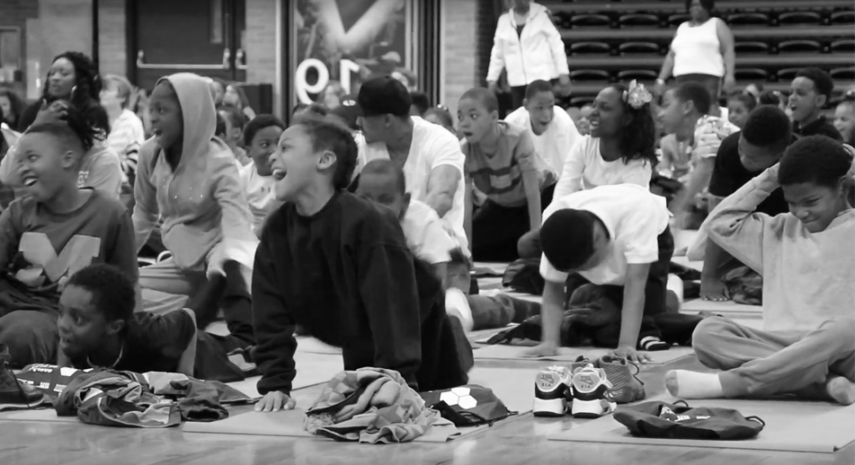 A group of students sit on the floor together. 