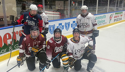 Hockey players pose on the ice at the Shocks and Saves Charity Hockey game.
