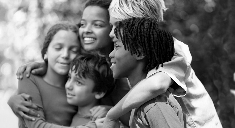 A group of young children embrace 