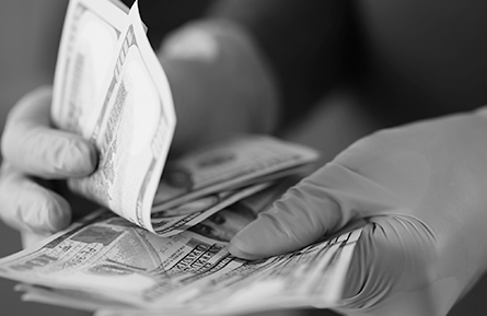 A person's gloved hands count money