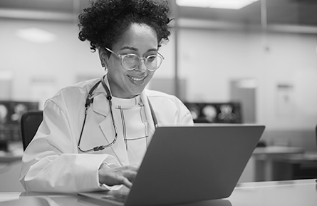 A female health care provider works on her laptop