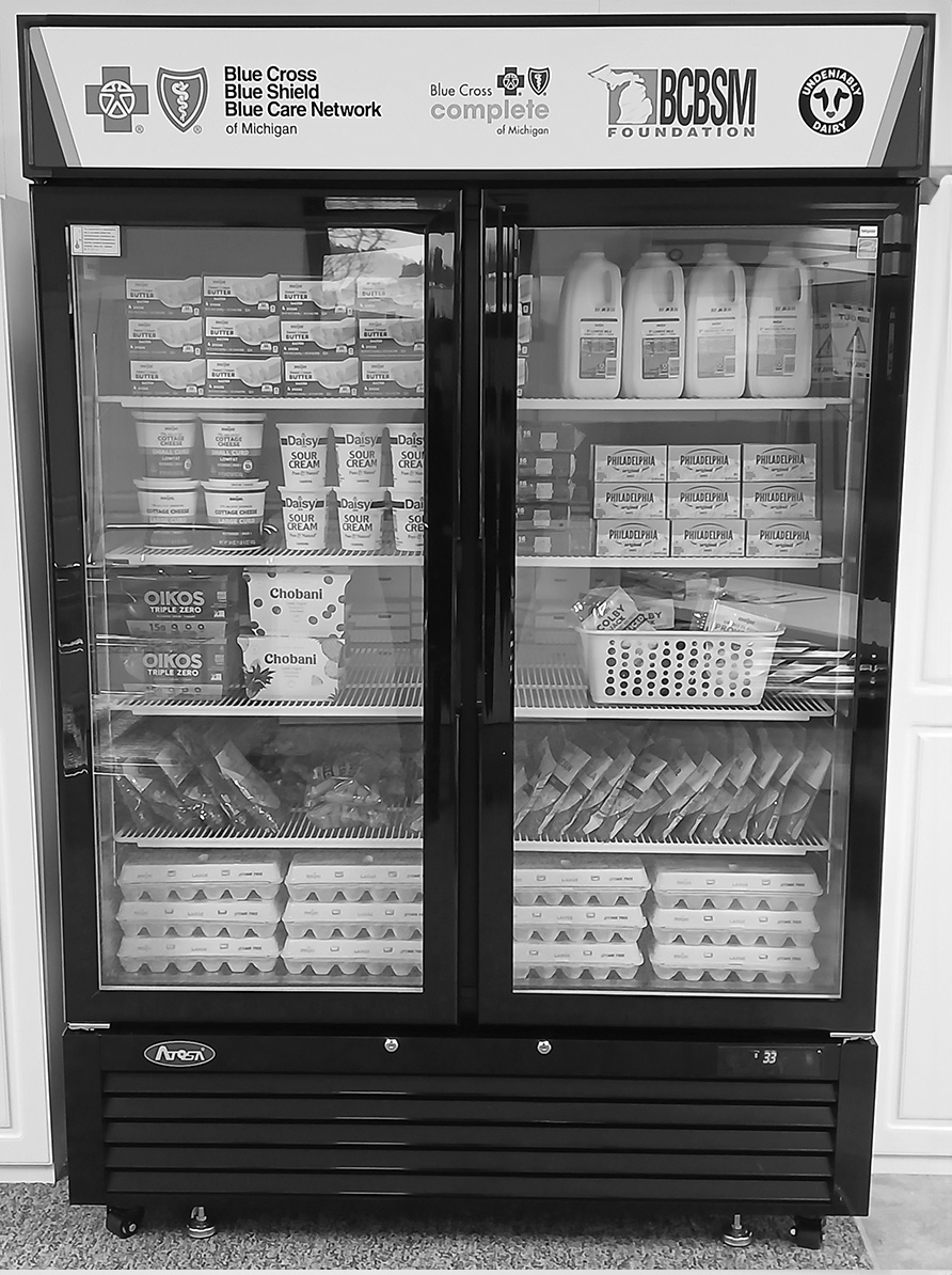 A refrigerator is packed with fresh produce and dairy products