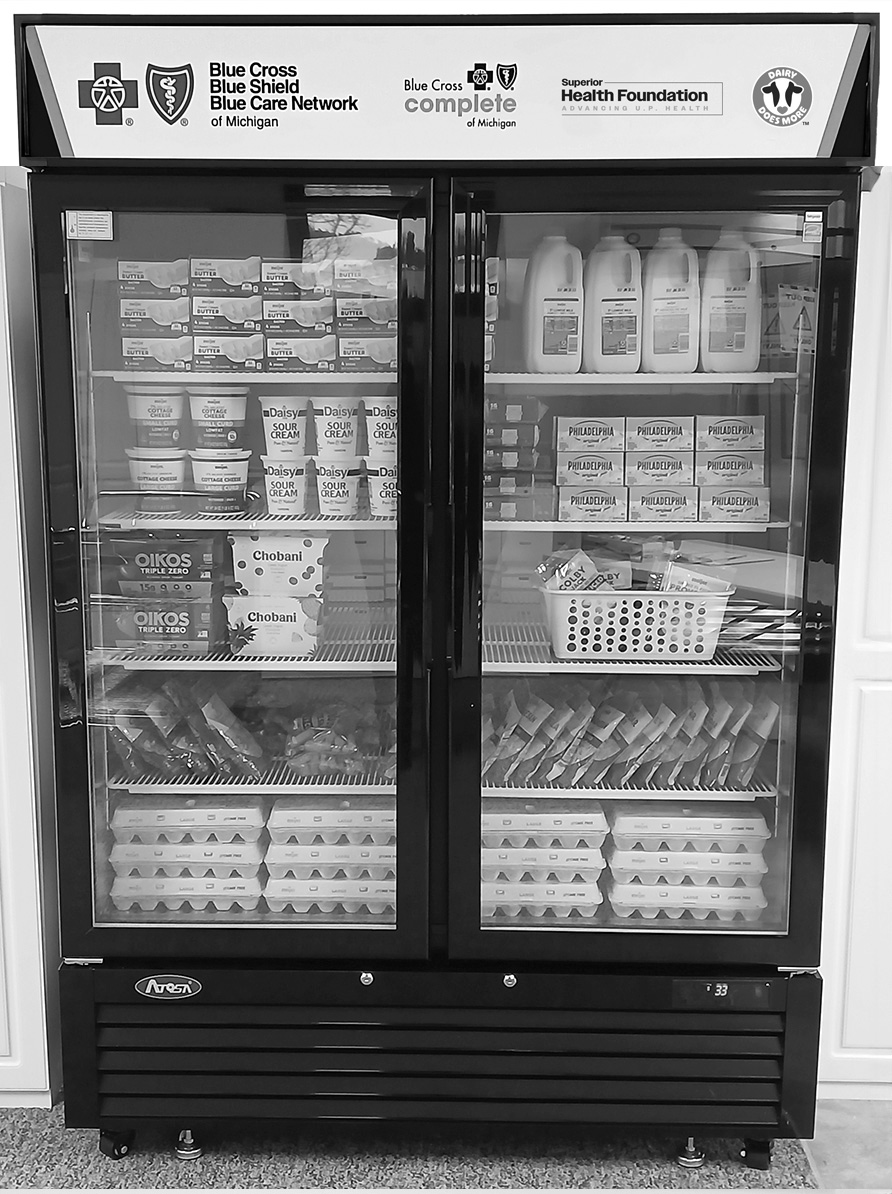 A refrigerator is packed with fresh produce and dairy products