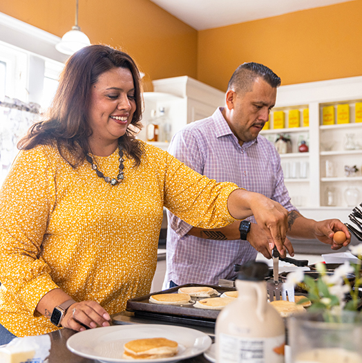A couple in their kitchen cooks together.
