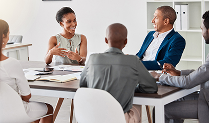 Employees sit and discuss fun facts during a meeting