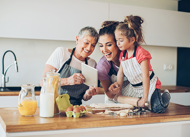 A little girl bakes with her mother and grandmother 