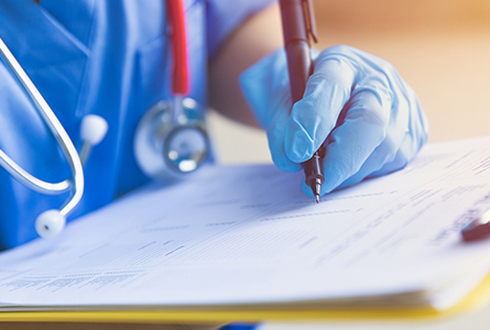 A doctor writing on a clipboard