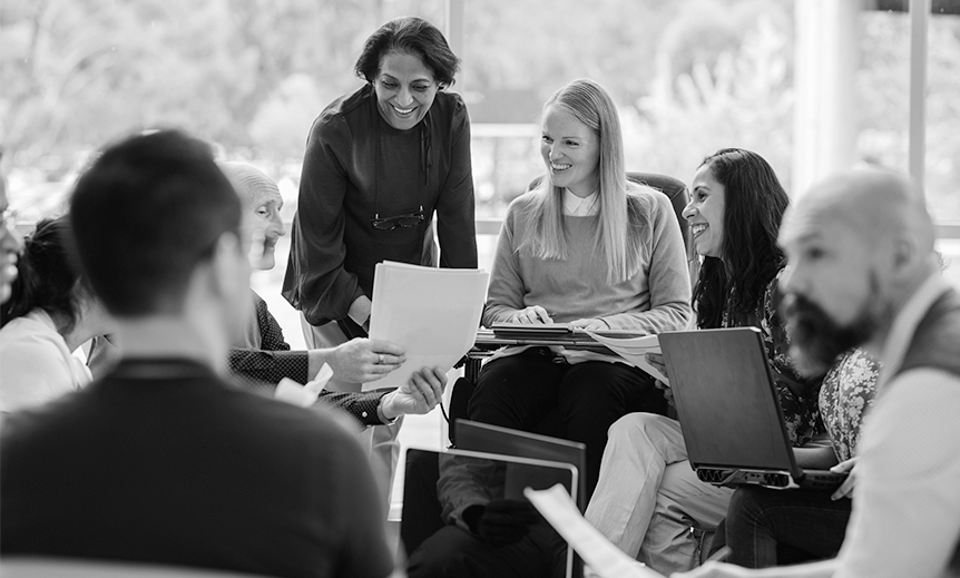A group of people sit in a meeting together