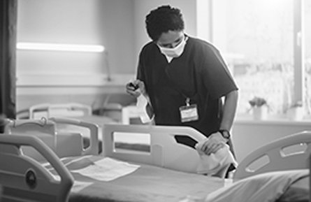 A health care professional sanitizing a room