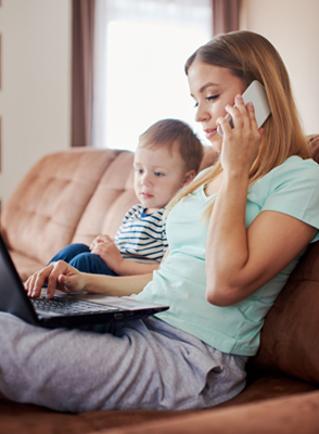Woman sitting on couch with child talking on phone